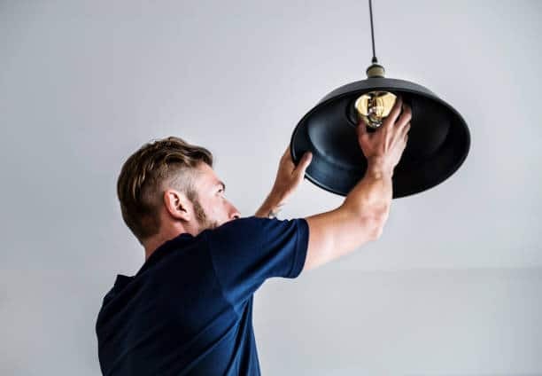 Man installing a downlight for home lighting in Johannesburg, supplied by wholesale distributors
