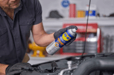 Man using automotive lubricants on a car for maintenance and repair in Johannesburg